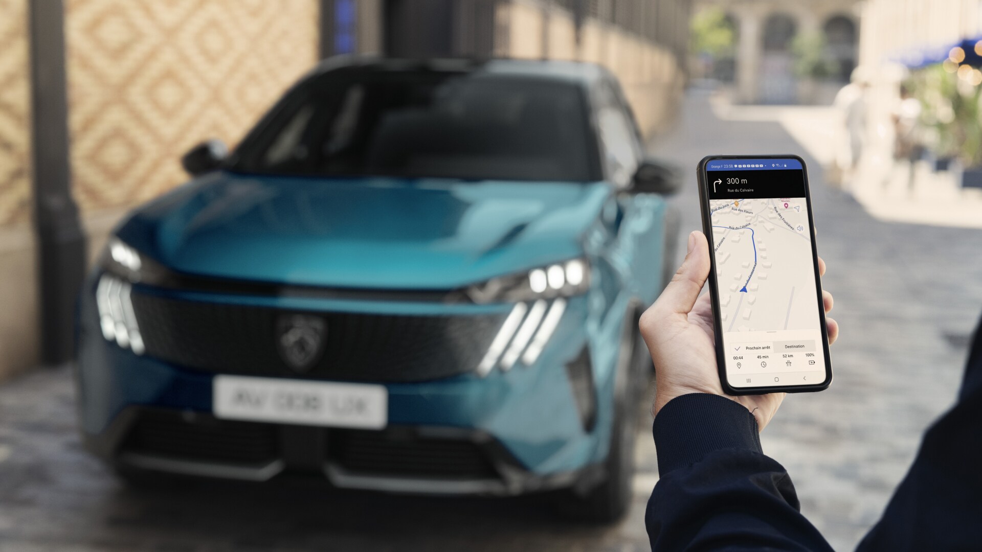 Een man kijkt op zijn smartphone bij de PEUGEOT 3008